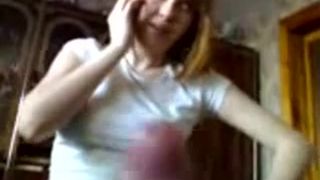 Рыжая русская девка болтает по телефону и одновременно дрочит член своего парня